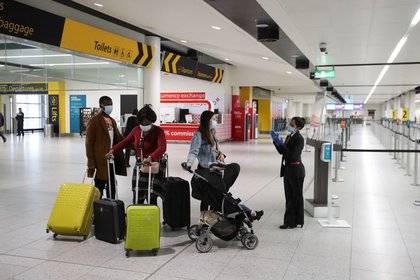 FOTO DE ARCHIVO: Pasajeros con mascarillas en el aeropuerto de Gatwick, Reino Unido, el 15 de junio de 2020. REUTERS/Peter Cziborra