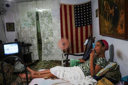 Ana Mercedes descansa en su casa junto a una bandera estadounidense en el centro de La Habana, Cuba. 17 de marzo de 2021. Fotografía tomada el 17 de marzo de 2021. REUTERS/Alexandre Meneghini