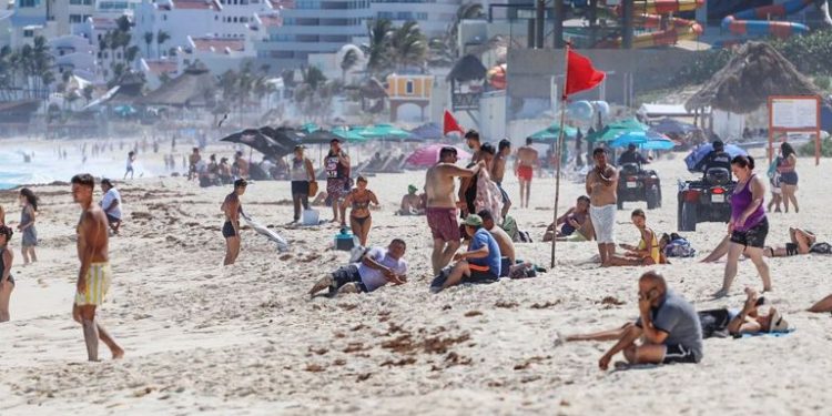 Decenas de turistas en Playa Delfines, en Cancún, el pasado 13 de marzo.
