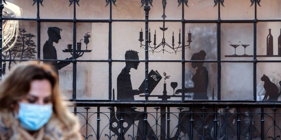 Foto: Una mujer con mascarilla pasa delante de un restaurante. (EFE)