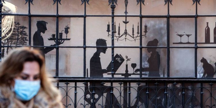 Foto: Una mujer con mascarilla pasa delante de un restaurante. (EFE)