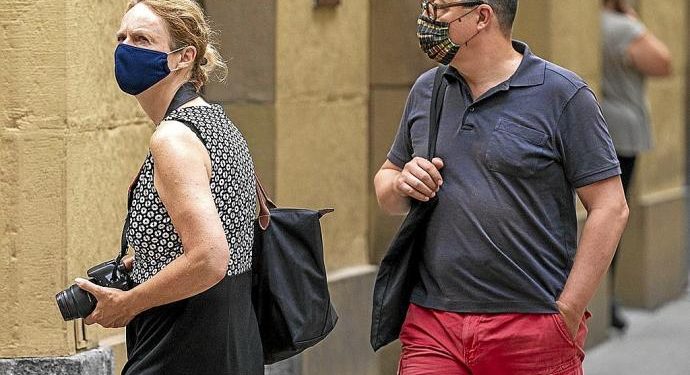 Dos turistas pasean por la Parte Vieja donostiarra.