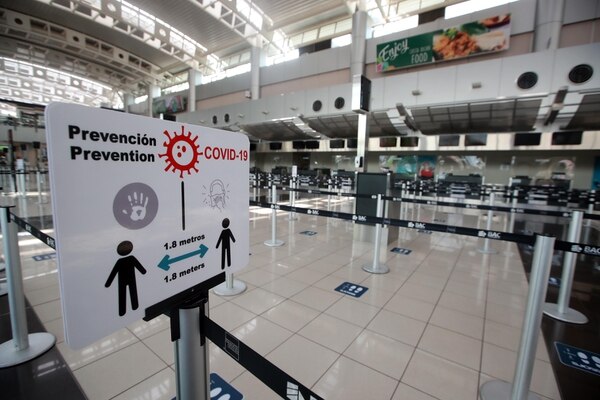 En el Aeropuerto Juan Santamaría, las zonas están marcadas en el piso con la distancia correcta, se colocaron rótulos para mantener la distancia y dispensadores de alcohol en gel, y acrílicos en counter, entre otras medidas. (Fotografía: Alonso Tenorio/Archivo)