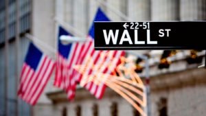 Cartel de la calle Wall Street en la foto delante de varias banderas estadounidenses que representan las acciones estadounidenses