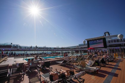 Pasajeros disfrutan del sol junto a una piscina a bordo del crucero MSC Grandiosa en Civitavecchia, cerca de Roma, el 31 de marzo de 2021 (Foto AP/Andrew Medichini)