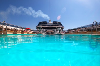 Pasajeros disfrutan del sol junto a una piscina a bordo del crucero MSC Grandiosa en Civitavecchia, cerca de Roma, el 31 de marzo de 2021 (Foto AP/Andrew Medichini)