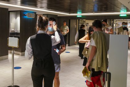 Empleados miden la temperatura de pasajeros al entrar a un restaurante en el crucero MSC Grandiosa en Civitavecchia, cerca de Roma, el 31 de marzo de 2021 (Foto AP/Andrew Medichini)