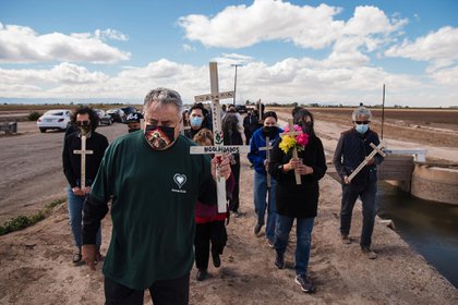 Enrique Morones, al centro, y un grupo de dolientes llevan cruces con los nombres de las trece víctimas, todos mexicanos indocumentados y migrantes guatemaltecos, que murieron el 2 de marzo de 2021, cuando un vehículo utilitario deportivo chocó con un semirremolque cerca de Holtville, California, 10 de marzo de 2021. (Ariana Drehsler/The New York Times)