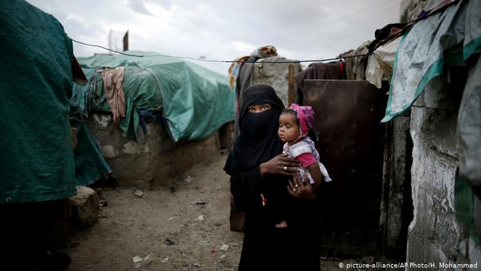 A woman of the Muhammasheen tribe holds her child in a camp for displaced persons