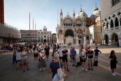 Turistas con  mascarillas escuchando a un guía en una visita a la Plaza de San Marcos en Venecia. 
Sep 11, 2020. REUTERS/Guglielmo Mangiapane