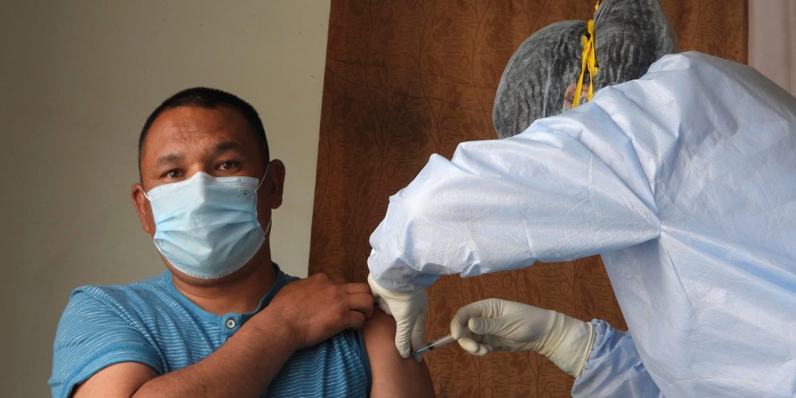 Una técnica sanitaria inyecta a un hombre una dosis de la vacuna Covishield contra el covid-19, el 6 de mayo de 2021 en Leh (India)
