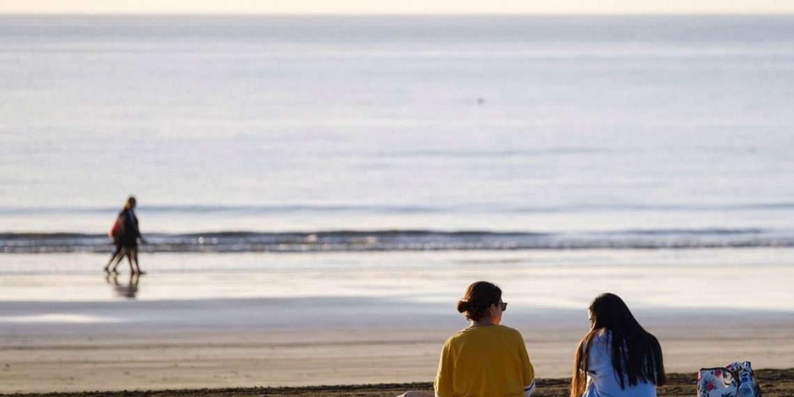 Foto: Dos jóvenes charlan en la playa de Maspalomas, en el sur de Gran Canaria. (EFE)