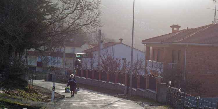 Foto: Una mujer camina por la carretera de Navacepedilla de Corneja. (David Brunat)