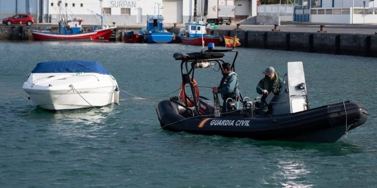 Foto: Agentes de la Guardia Civil remolcan la embarcación del padre de Anna y Olivia. (EFE)