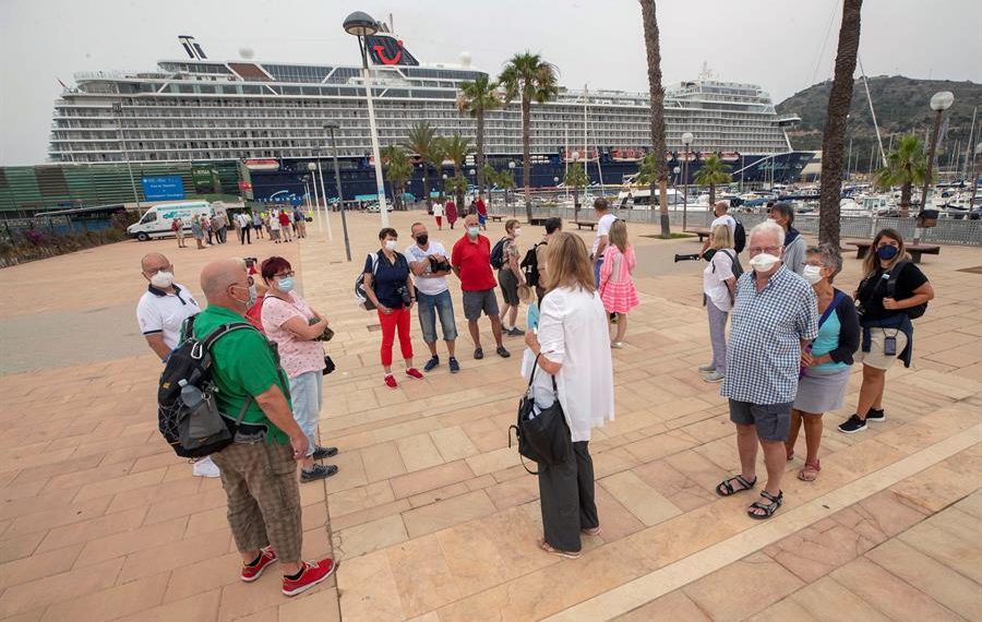 Un grupo de turistas alemanes del "Mein Schiff 2", el primer crucero que atraca en el Puerto de Cartagena tras la suspensi&oacute;n del turismo mar&iacute;timo desde marzo de 2020 a causa de la pandemia del coronavirus, atiende a las explicaciones de una gu&iacute;a tur&iacute;stica este s&aacute;bado. El "Mein Schiff 2" lleg&oacute; hoy a Cartagena con unos mil turistas alemanes a bordo procedentes de Palma de Mallorca. EFE/Marcial Guill&eacute;n