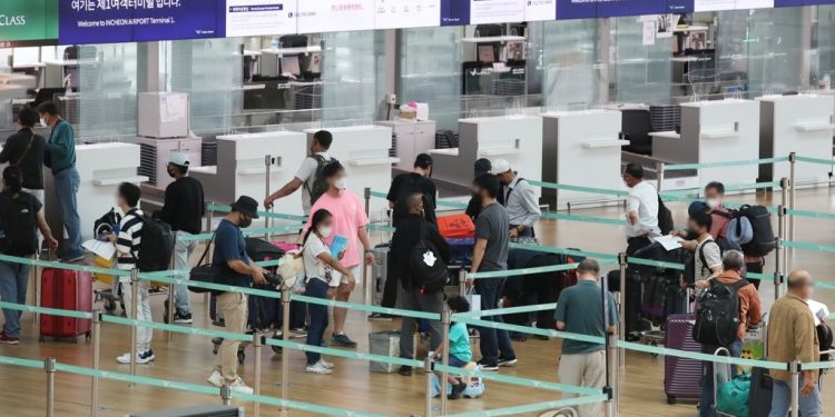 La foto de archivo muestra a viajeros al extranjero esperando en fila, el 7 de julio de 2021, para facturar en la Terminal 1 del Aeropuerto Internacional de Incheon, al oeste de Seúl.
