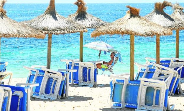 Un turista británico toma el sol en la playa mayorquina de Magaluf./E. Calvo / reuters