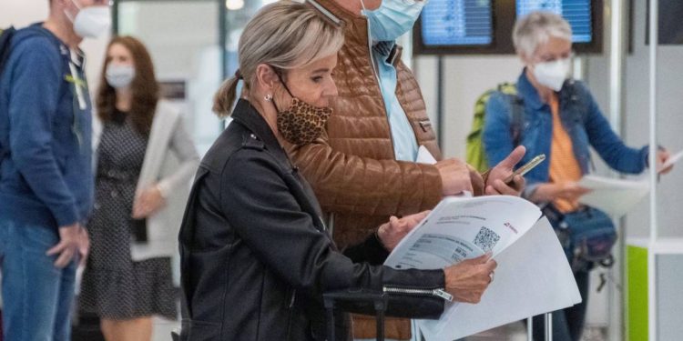 Foto: Unos viajeros revisan sus papeles en el aeropuerto de Palma de Mallorca. (EFE)
