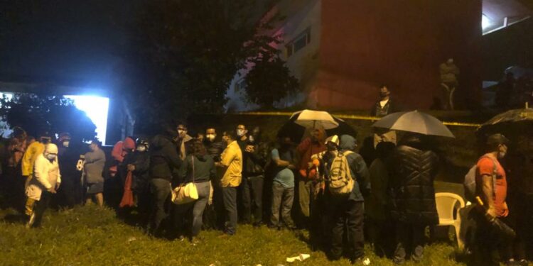 Habitantes de El Crucero hacen fila bajo la lluvia para vacunarse este sábado