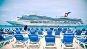 Crucero Carnival (CCL) sobre el agua frente a la playa con sillas