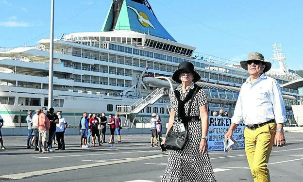 Dos pasajeros alemanes abandonan la zona de atraque del 'Artania' para conocer los atractivos de Getxo. /PEDRO URRESTI