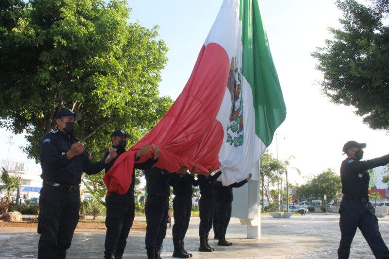 Izan bandera nacional en el parque del Crucero en Cancún