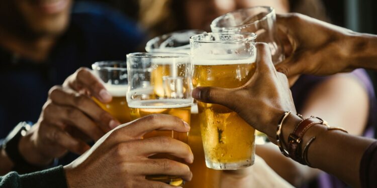 manos sosteniendo tarros de cerveza