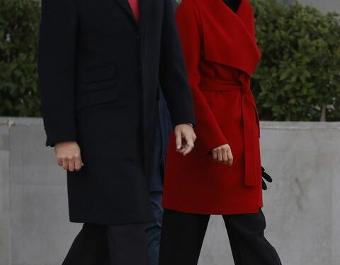 la reina letizia con el abrigo bata rojo de hugo bos, pantalones culotte negros y botas altas negras con tacón en la despedida antes de iniciar su viaje oficial a suecia