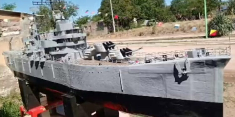 Caravana con una maqueta de cartón del Crucero Belgrano