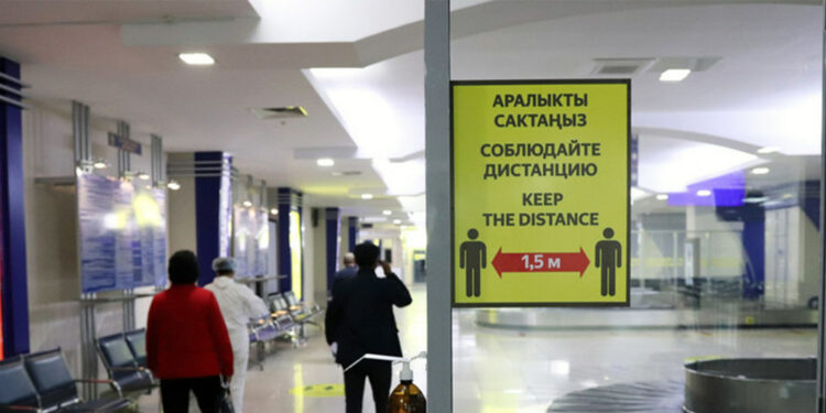 Cartel con advertencias de seguridad frente al COVID-19 en un aeropuerto de Kyrgyzstan