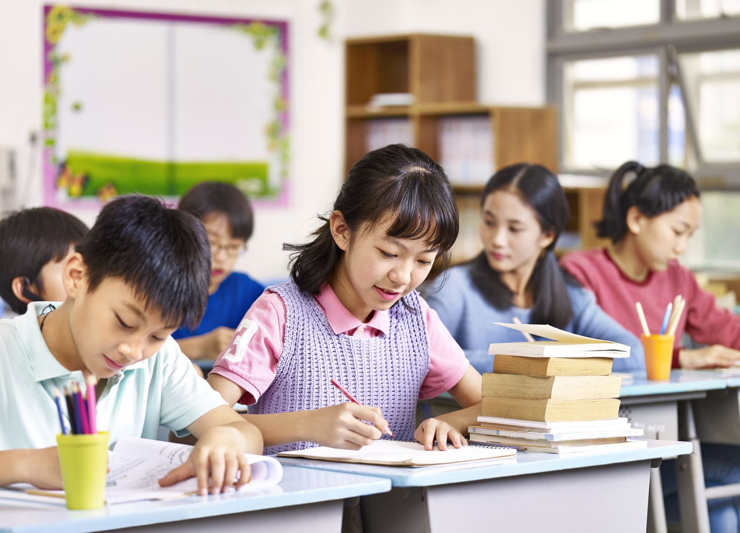 grupo de niños y niñas asiáticos de primaria que estudian en clase.