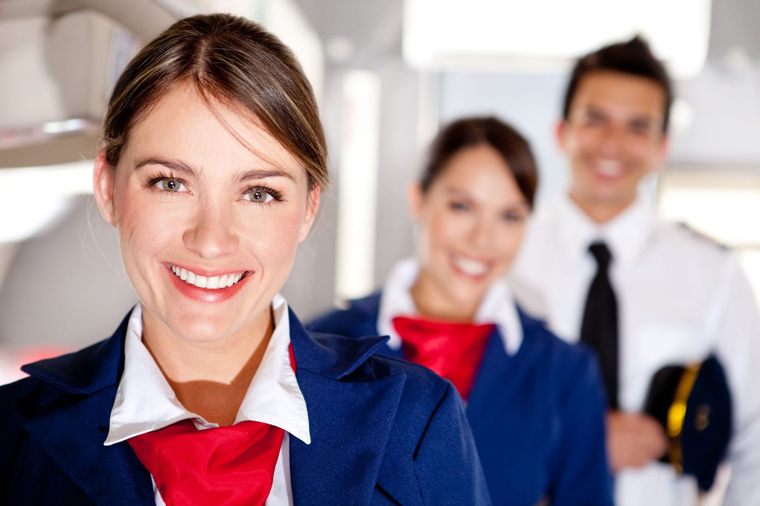 Azafata con la tripulación de cabina del avión sonriendo