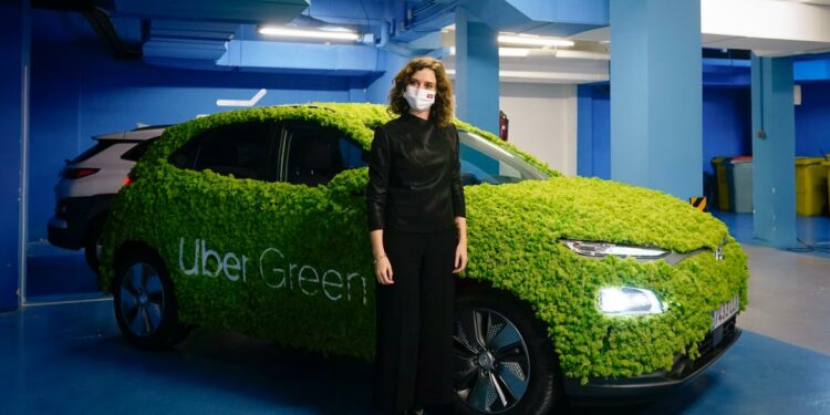 La presidenta posando con un coche verde en el que se ve escrita la marca Uber Green