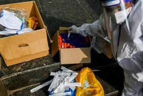 Un sanitario guarda unas muestras recogidas para realizar pruebas de covid-19 en ele exterior de una estación de metro de Nueva Delhi el 2 de enero de 2022 (afp_tickers)