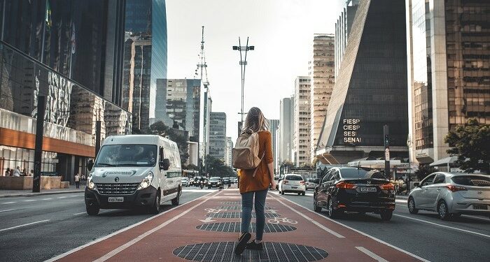 Mujer con mochila sola en la ciudad