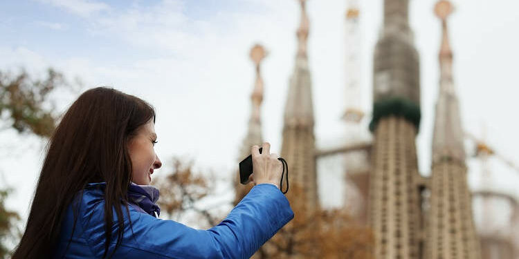 Joven fotografía la Sagrada Familia en Barcelona.
