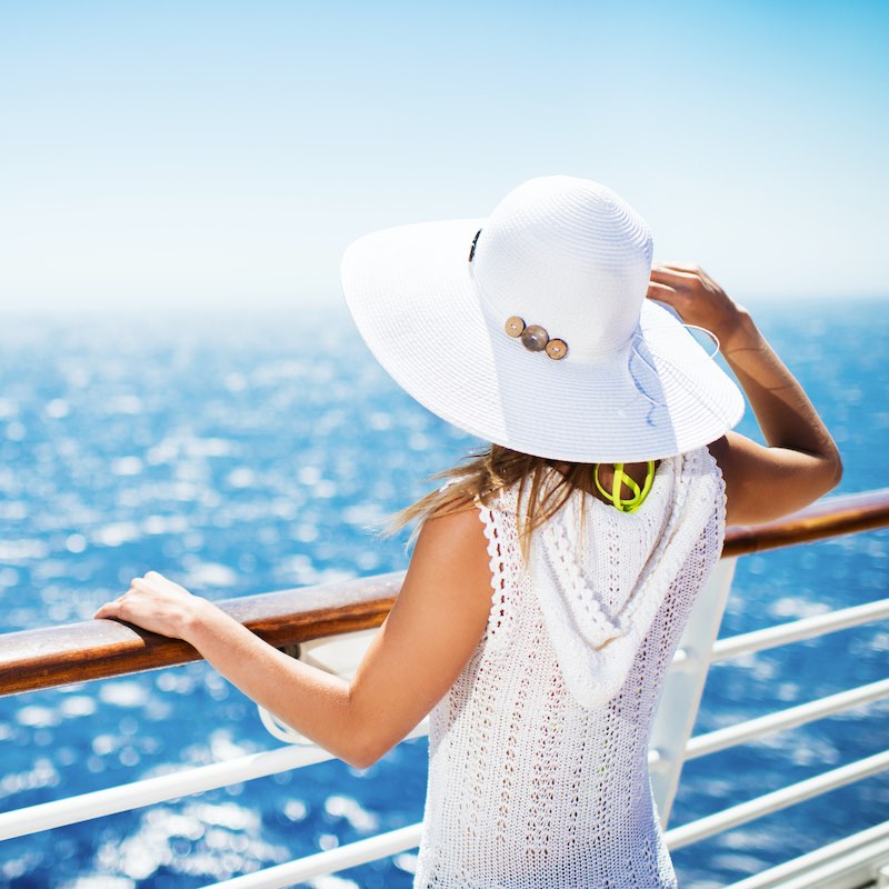 mujer con sombrero en un crucero mirando la vista