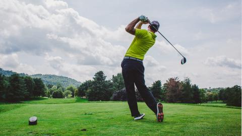 Persona jugando al golf en un campo nublado