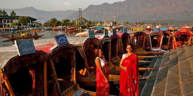 FOTO DE ARCHIVO: Turistas posan en "Shikaras" o botes estacionados a orillas del lago Dal en Srinagar, India, 5 de abril de 2022. REUTERS/Danish Ismail