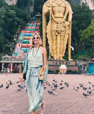 Dolores en su visita a las Cuevas de Batu, ubicadas a 13 kilómetros al norte de Kuala Lumpur. Detrás de ella, se ve la gigantesca estatua dorada del dios Murugan.