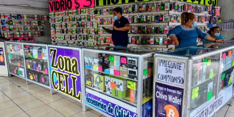 Trabajadores de una tienda de accesorios para teléfonos móviles que acepta bitcoin como método de pago en el Centro Histórico de San Salvador.