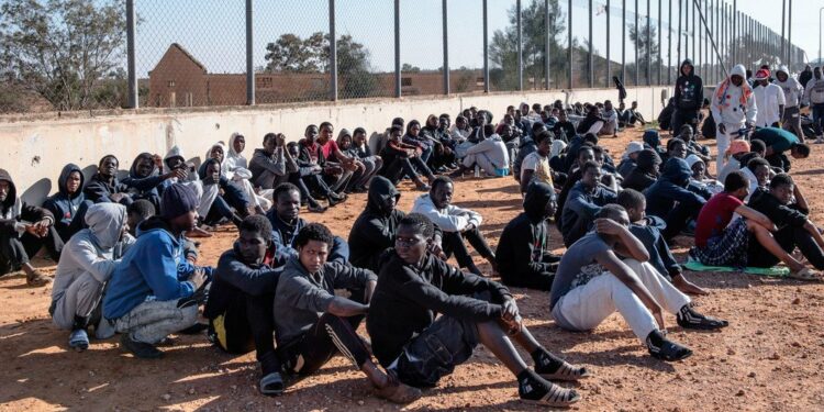 Migrantes sentados en el patio de un centro de detención en Libia (imagen de archivo).