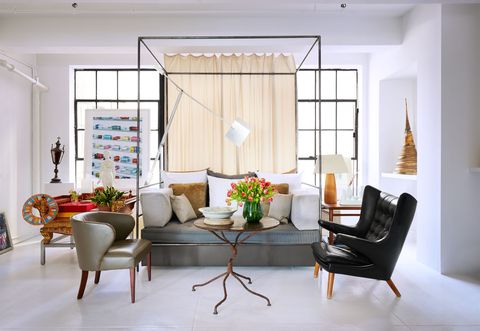 guest den daybed in raw steel, two leather armchairs, cast iron accent table, a floor and a table lamp, painting by damien hirst, and a stupa from thailand