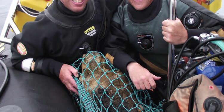 En esta foto sin fecha proporcionada por Norfolk Historic Shipwrecks, Julian y Lincoln Barnwell posan para una foto con la campana del HMS Gloucester, encontrada en 2007. Excavadores e historiadores le cuentan al mundo sobre el naufragio de un buque de guerra real que se hundió en 1682 mientras transportaba el futuro rey James Stuart. El HMS Gloucester encalló mientras navegaba por bancos de arena frente a la ciudad de Great Yarmouth, en la costa este de Inglaterra. Los restos del Gloucester fueron encontrados en 2007 por los hermanos Julian y Lincoln Barnwell y otros después de una búsqueda de cuatro años. (Norfolk Historic Shipwrecks via AP)