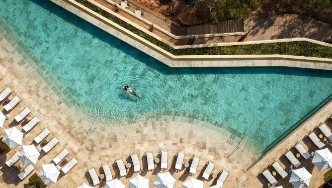 Vista de la piscina del hotel Six Senses Ibiza con sombrillas de Tuuci.