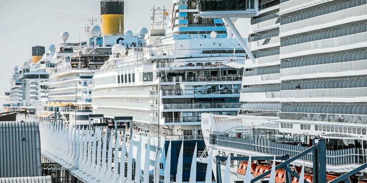 foto XAVIER CERVERA 22/10/2021 hoy ha sido el dia post pandemia con mas cruceros atracados en las terminales del puerto port de barcelona, un total de seis (msc, costa, tui,...) un turista toma una foto con el WTC reflejado en su telefono mobil