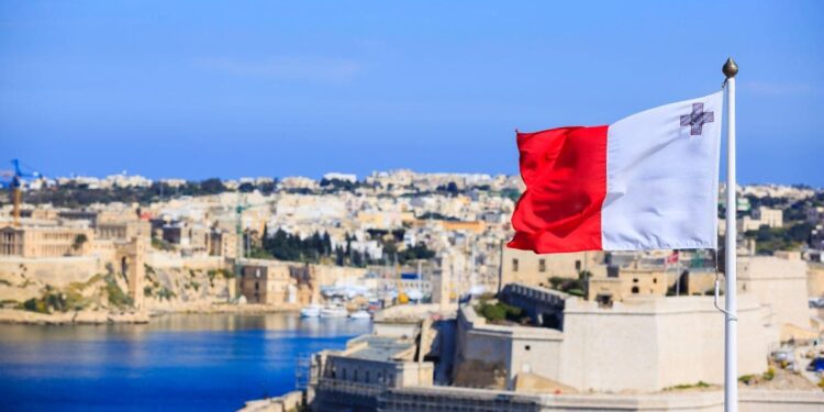 Bandera de Malta con parte de la ciudad al fondo