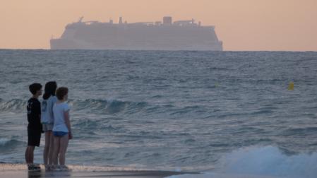 Expectación ante el paso de un gran crucero en la playa de Gavà.