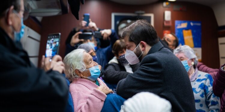 Imagen del Presidente Gabriel Boric conversando con una de las beneficiadas del Programa Vacaciones Tercera Edad abordo de un tren