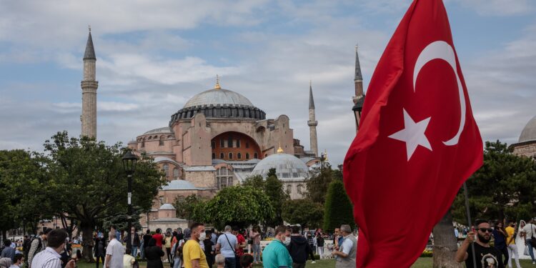 Imagen de archivo de un hombre agitando la bandera nacional de Turquía frente a la Mezquita de Santa Sofía. Foto: CHRIS MCGRATH- Europa Press